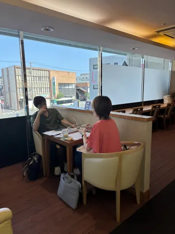 窓際の席で打ち合わせをするお客様